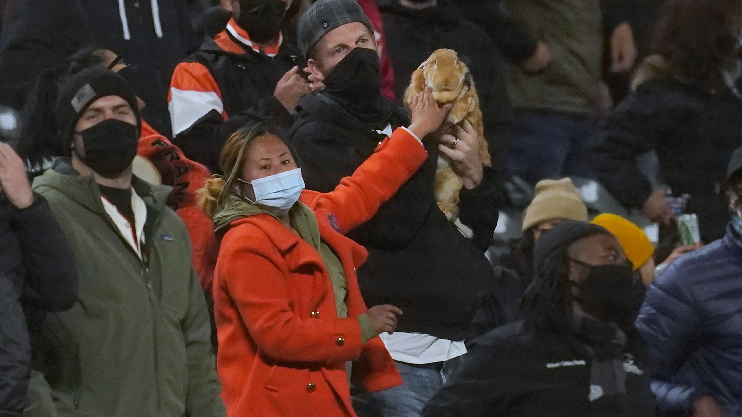 Kei Kato, left, and her fiance, Josh Row, hold a therapy rabbit named Alex during the ninth inning of a baseball game between the San Francisco Giants and the Miami Marlins in San Francisco, Thursday, April 22, 2021. (AP Photo/Jeff Chiu)