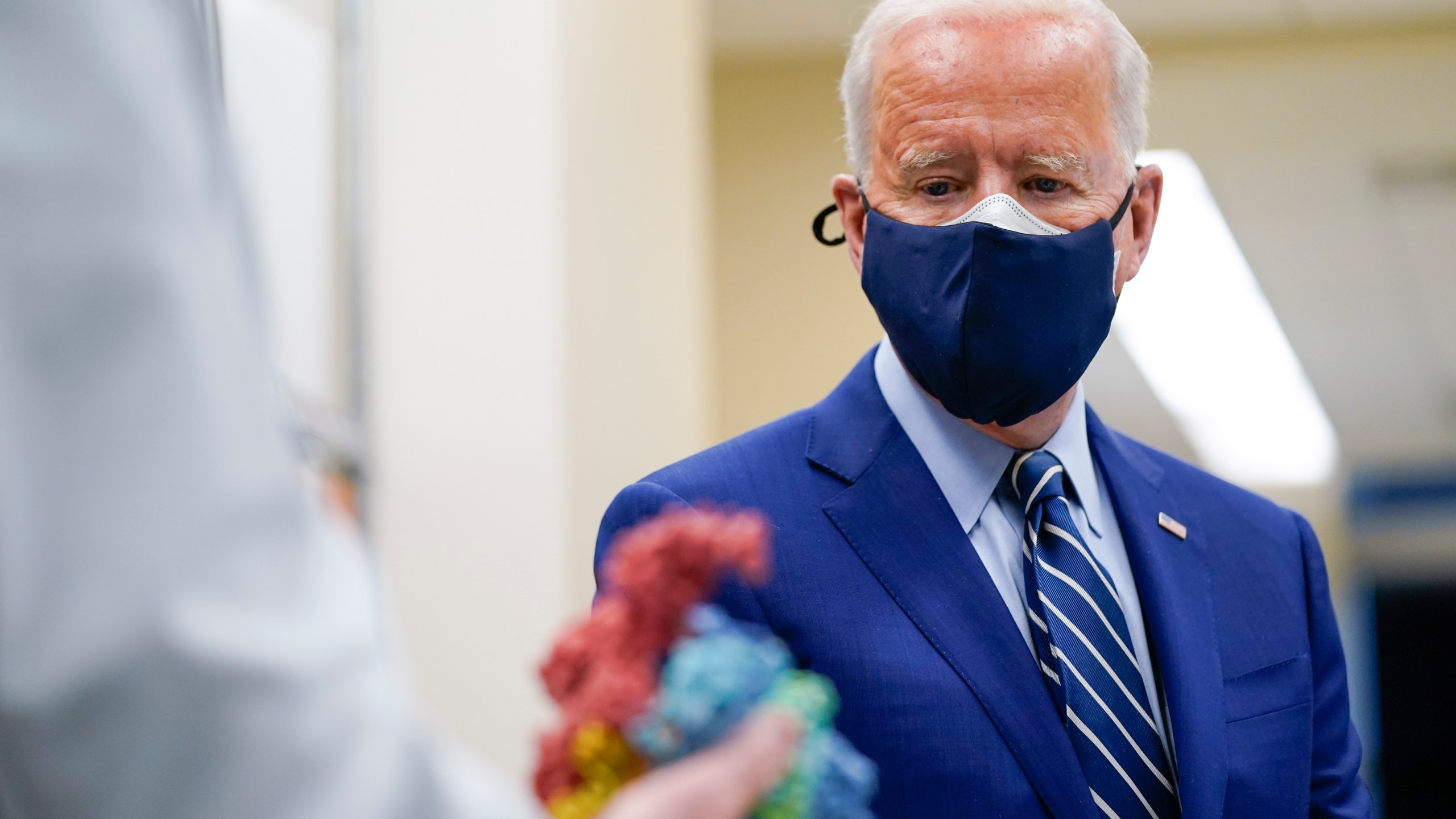 In this Feb. 11, 2021, file photo President Joe Biden looks at a model of Covid-19 as he visits the Viral Pathogenesis Laboratory at the National Institutes of Health in Bethesda, Md. (AP Photo/Evan Vucci, File)