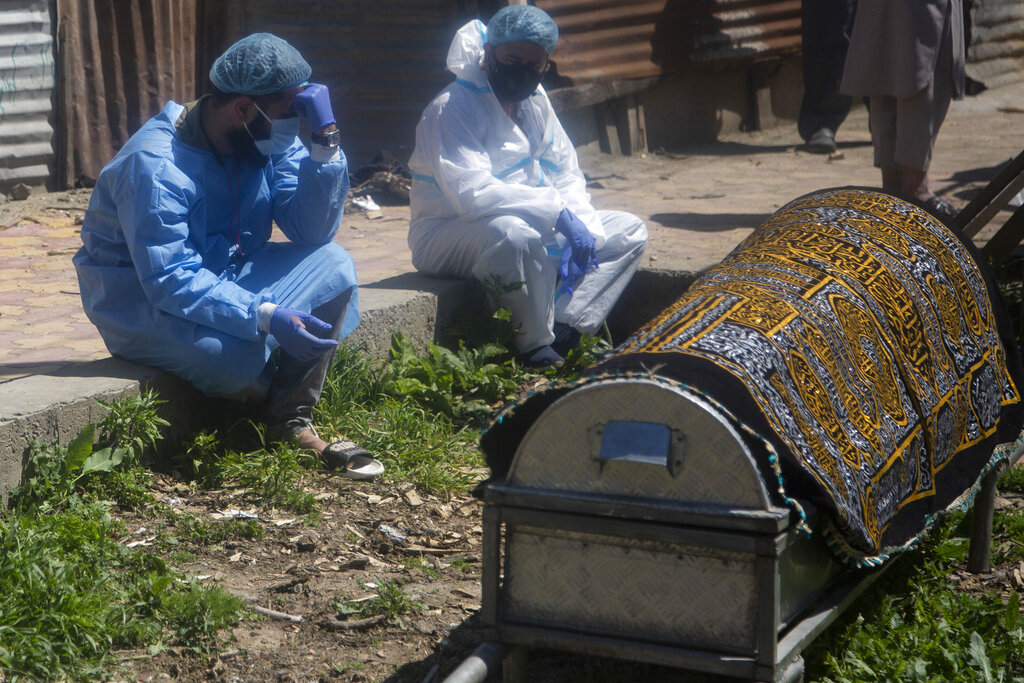 Relatives mourn near a coffin containing the body of a person who died of COVID-19 in Srinagar, Indian controlled Kashmir, on April 25, 2021. (AP Photo/Mukhtar Khan)