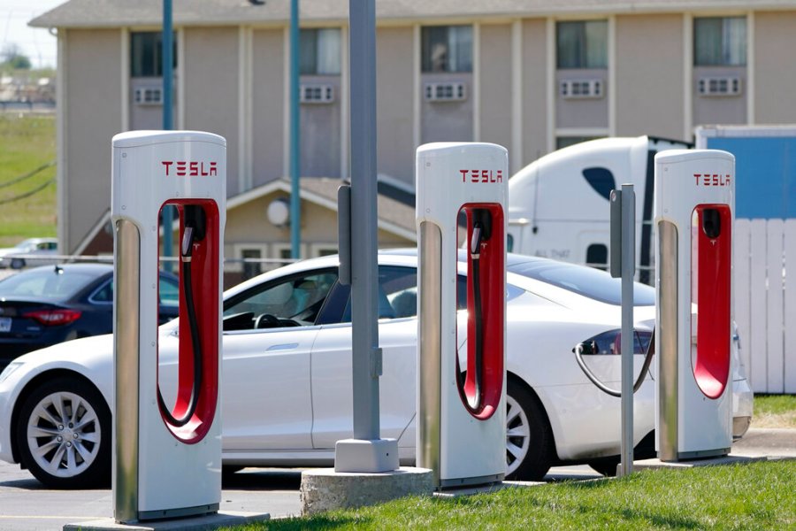 In this Monday, April 5, 2021 file photo, a Tesla electric vehicle charges at a station in Topeka, Kan. (AP Photo/Orlin Wagner)