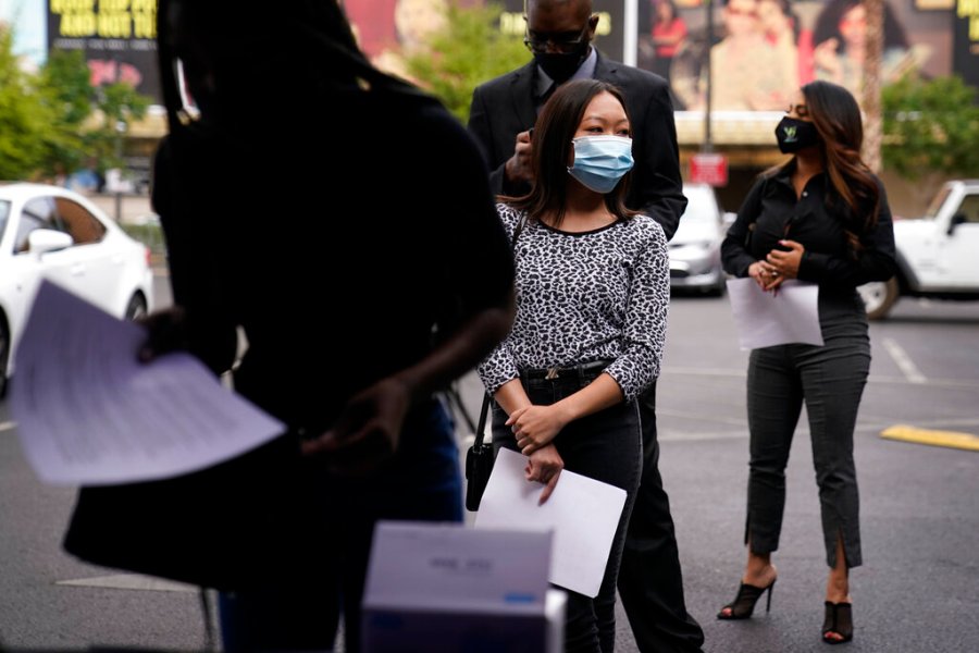 People wait in line, resumes in hand, while waiting to apply for jobs during an outdoor hiring event for the Circa resort and casino, Tuesday, April 27, 2021, in Las Vegas. (AP Photo/John Locher)