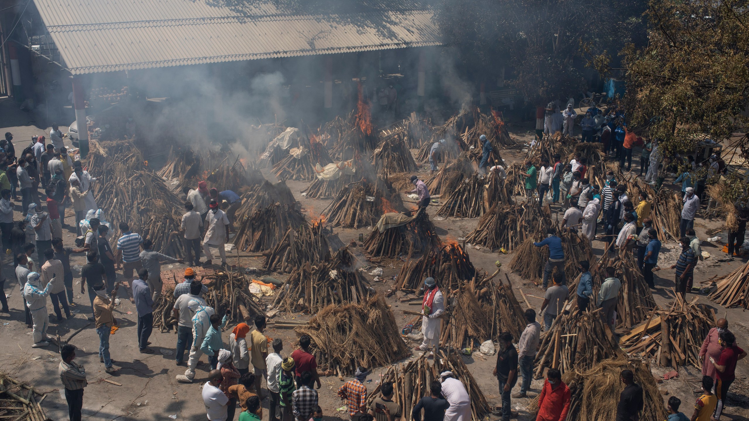 In this April 24, 2021, file photo, multiple funeral pyres of those who died of COVID-19 burn at a ground that has been converted into a crematorium for the mass cremation of coronavirus victims, in New Delhi, India. (AP Photo/Altaf Qadri, File)