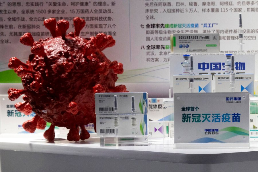 In this file photo taken Sept. 6, 2020, samples of a COVID-19 vaccine produced by Sinopharm subsidiary CNBG are displayed near a 3D model of a coronavirus during a trade fair in Beijing. (AP Photo/Ng Han Guan, File)