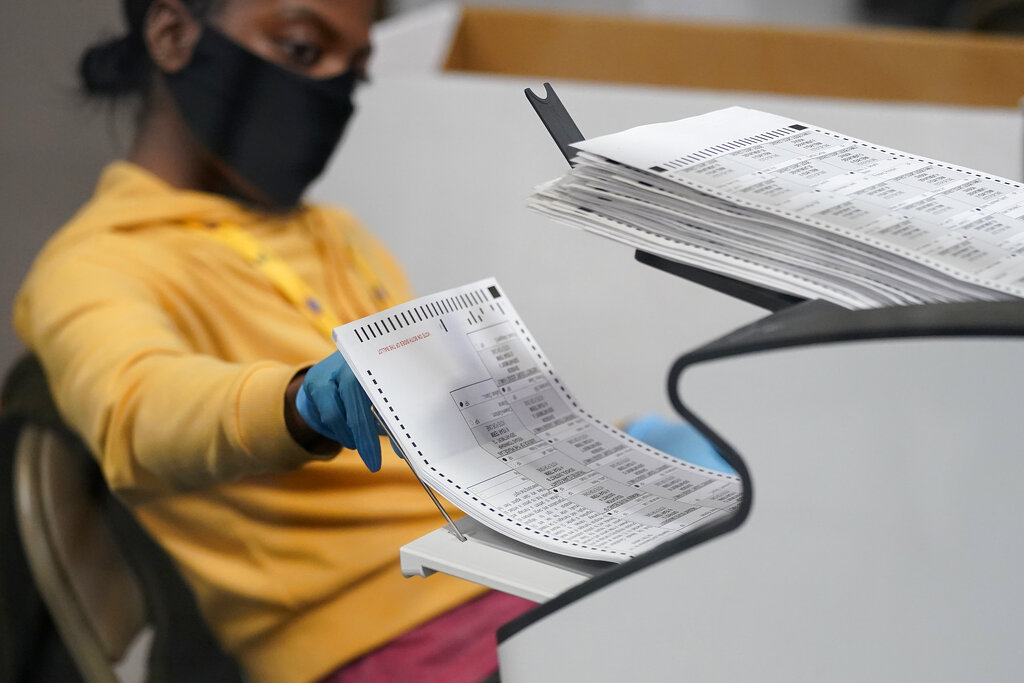 In this Nov. 5, 2020, file photo, a county election worker scans mail-in ballots at a tabulating area at the Clark County Election Department in Las Vegas. (AP Photo/John Locher, File)