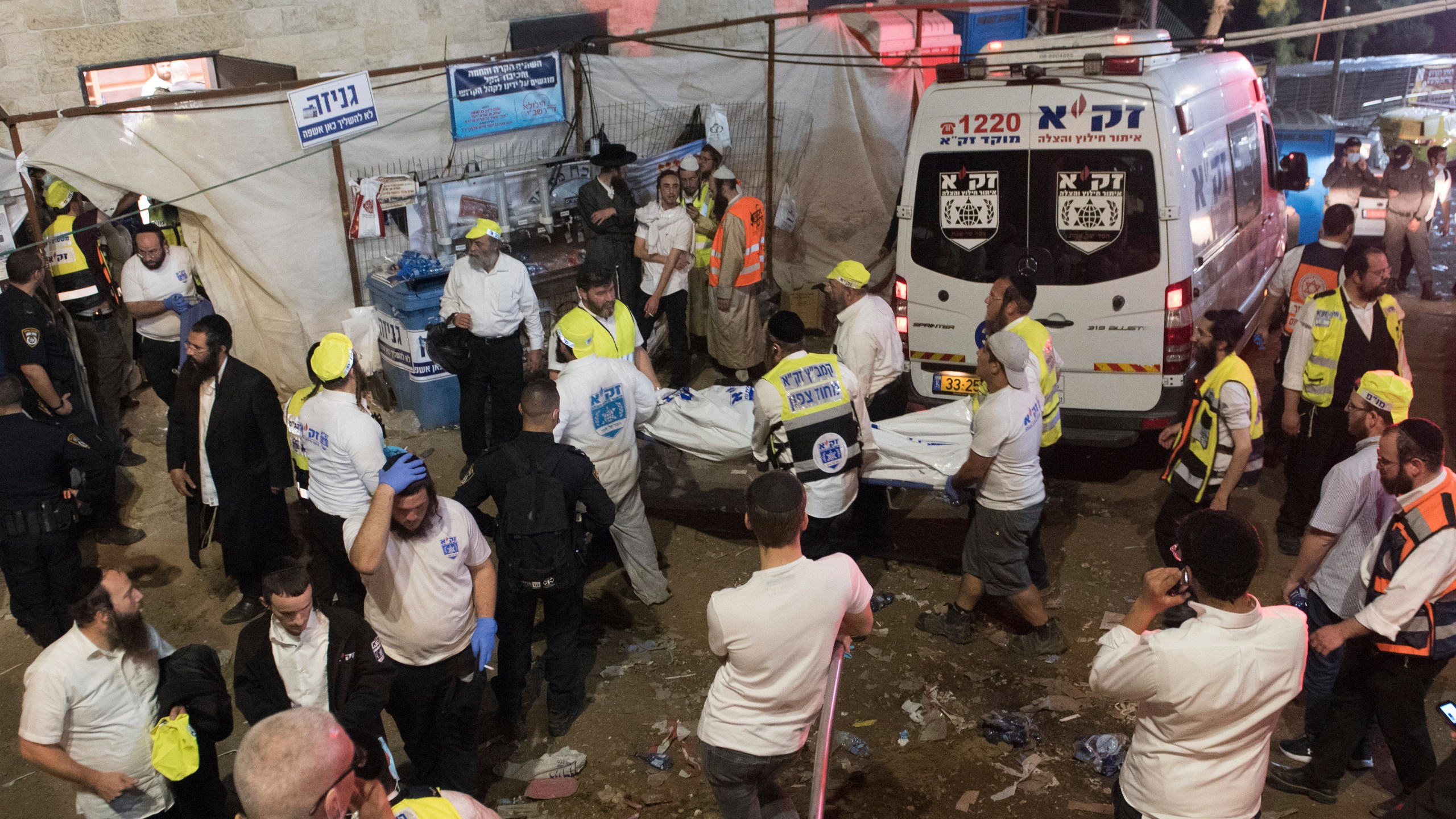 Israeli security officials and rescuers carry a body of a victim who died during a Lag Ba'Omer celebrations at Mt. Meron in northern Israel, Friday, April 30, 2021. (AP Photo)