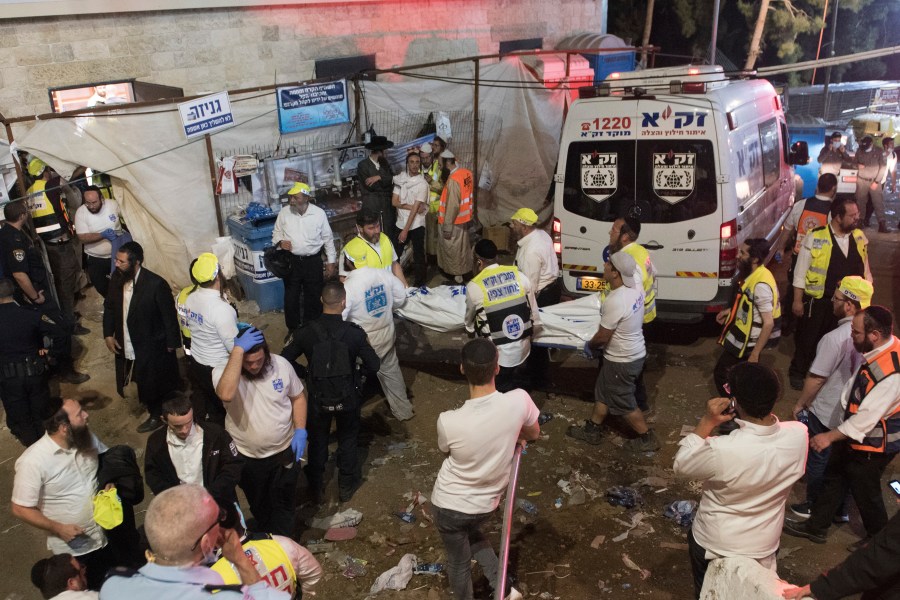 Israeli security officials and rescuers carry a body of a victim who died during a Lag Ba'Omer celebrations at Mt. Meron in northern Israel, Friday, April 30, 2021. (AP Photo)