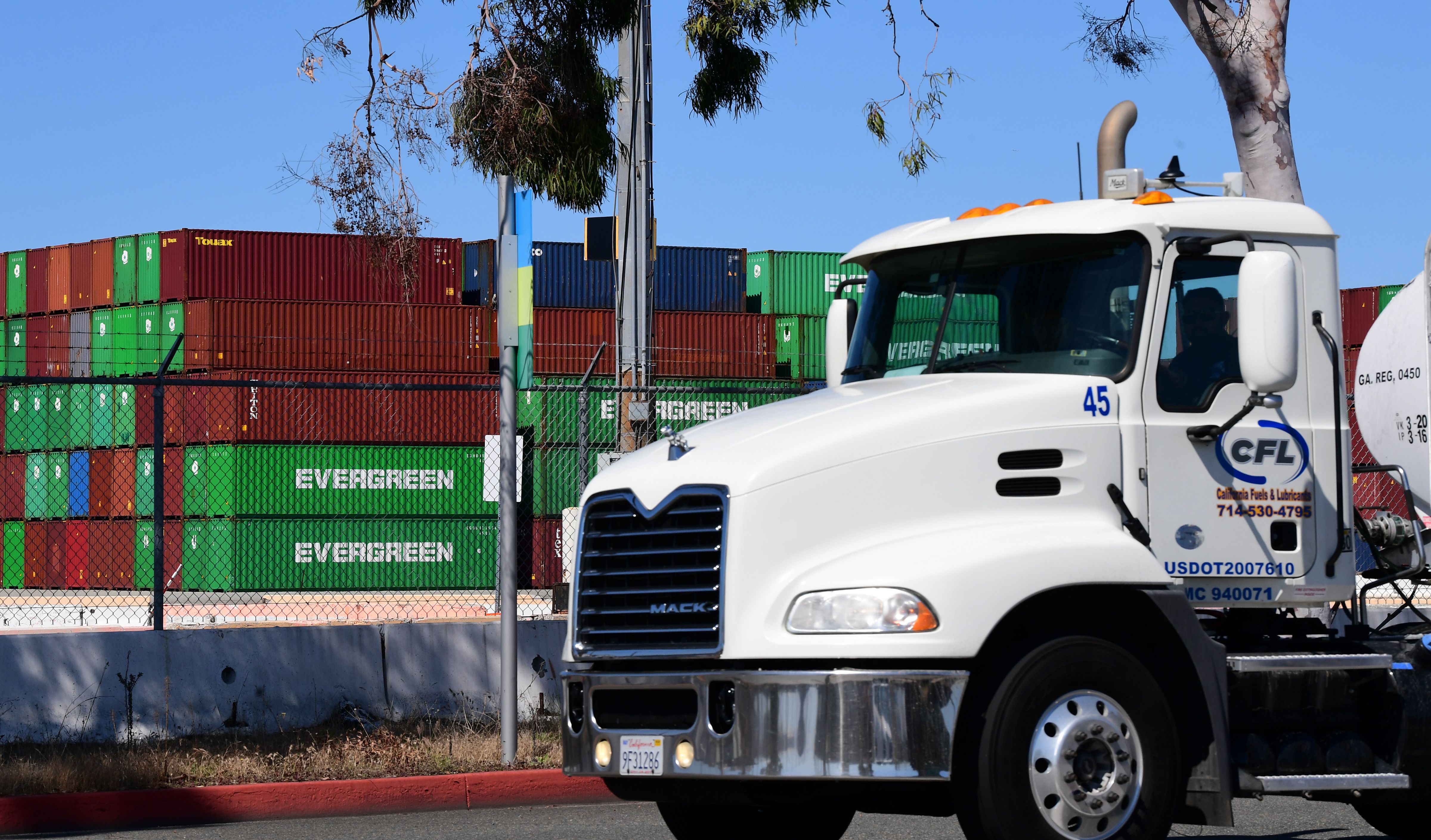 A container truck driver passes containers stacked high at the Port of Los Angeles on March 26, 2020. (Frederic J. Brown / AFP / Getty Images)