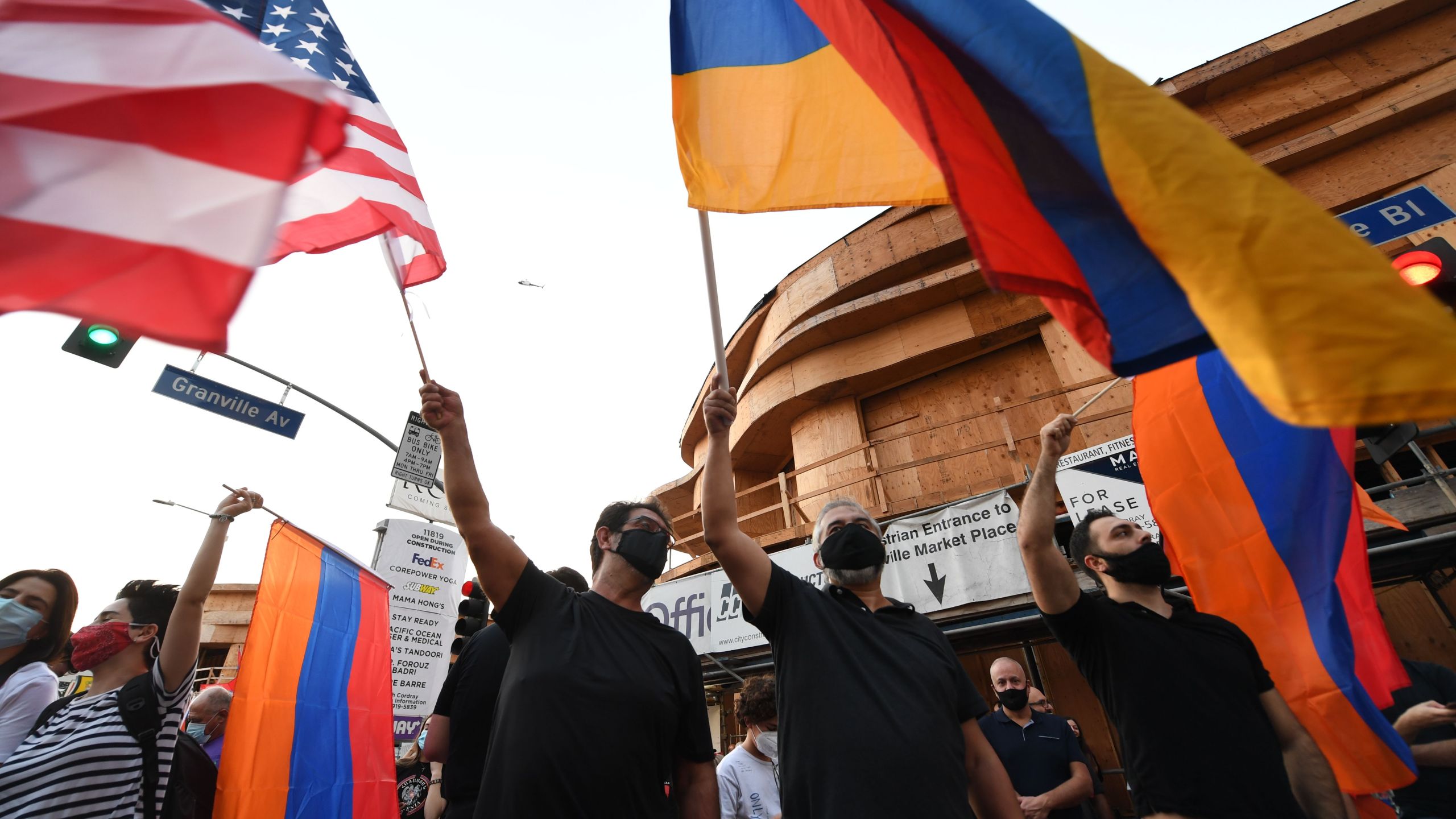 People wave U.S. and Armenian flags during a protest outside the Azerbaijani Consulate General in Los Angeles on September 30, 2020. (VALERIE MACON/AFP via Getty Images)