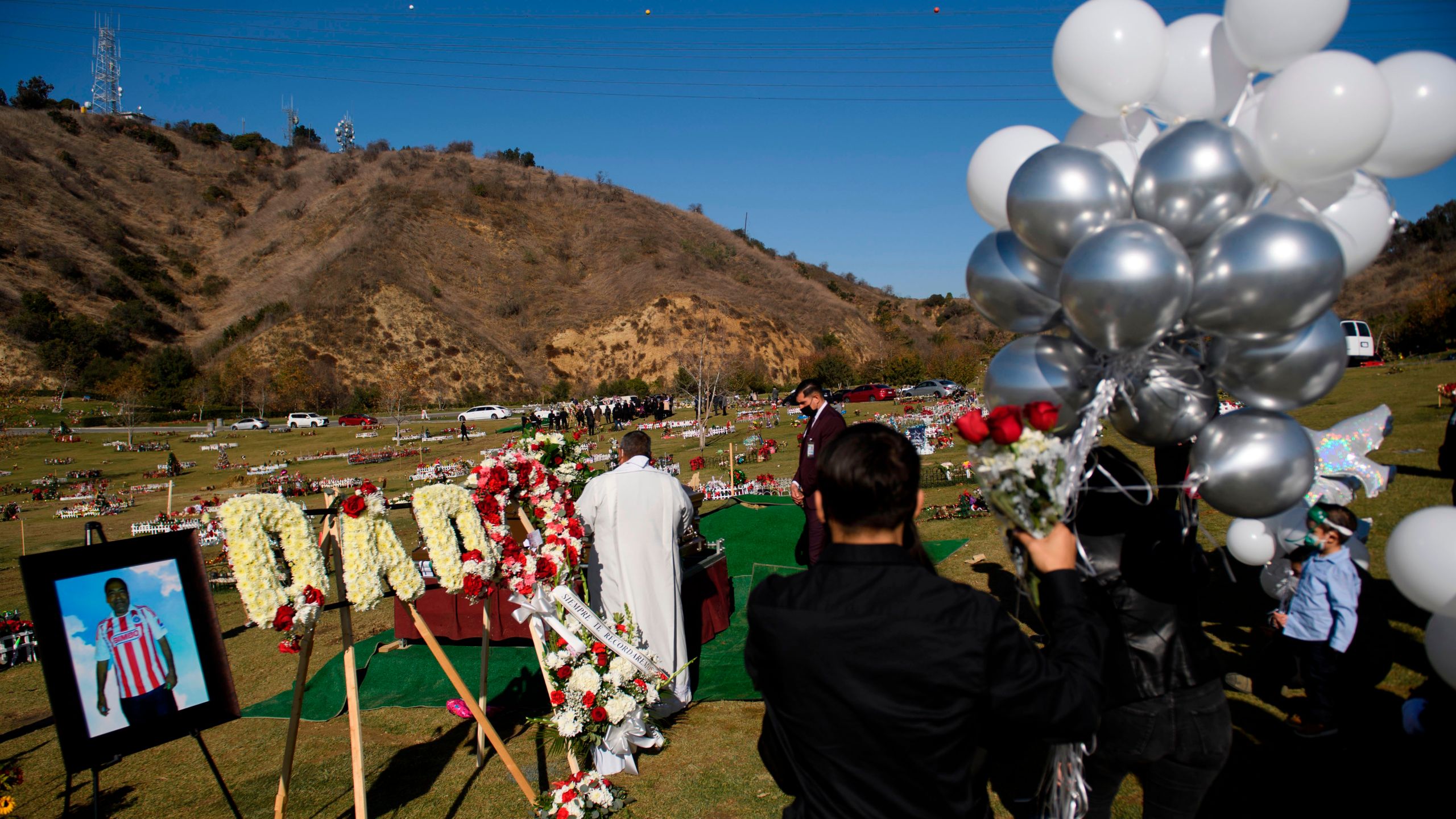 Family members mourn during a burial service for Gilberto Arreguin Camacho, 58, following his death due to COVID-19, at a cemetery on New Year's Eve, December 31, 2020 in Whittier, California. (PATRICK T. FALLON/AFP via Getty Images)