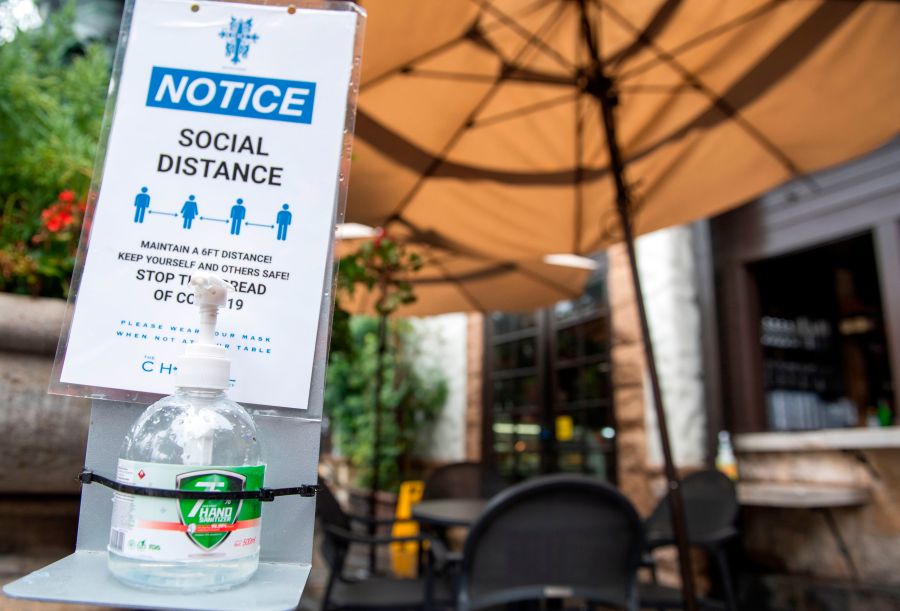 A notice calling for patrons to social distance along with hand sanitizer are seen in the outdoor seating area of The Abbey Food & Bar on Jan. 29, 2021 in West Hollywood. (VALERIE MACON/AFP via Getty Images)