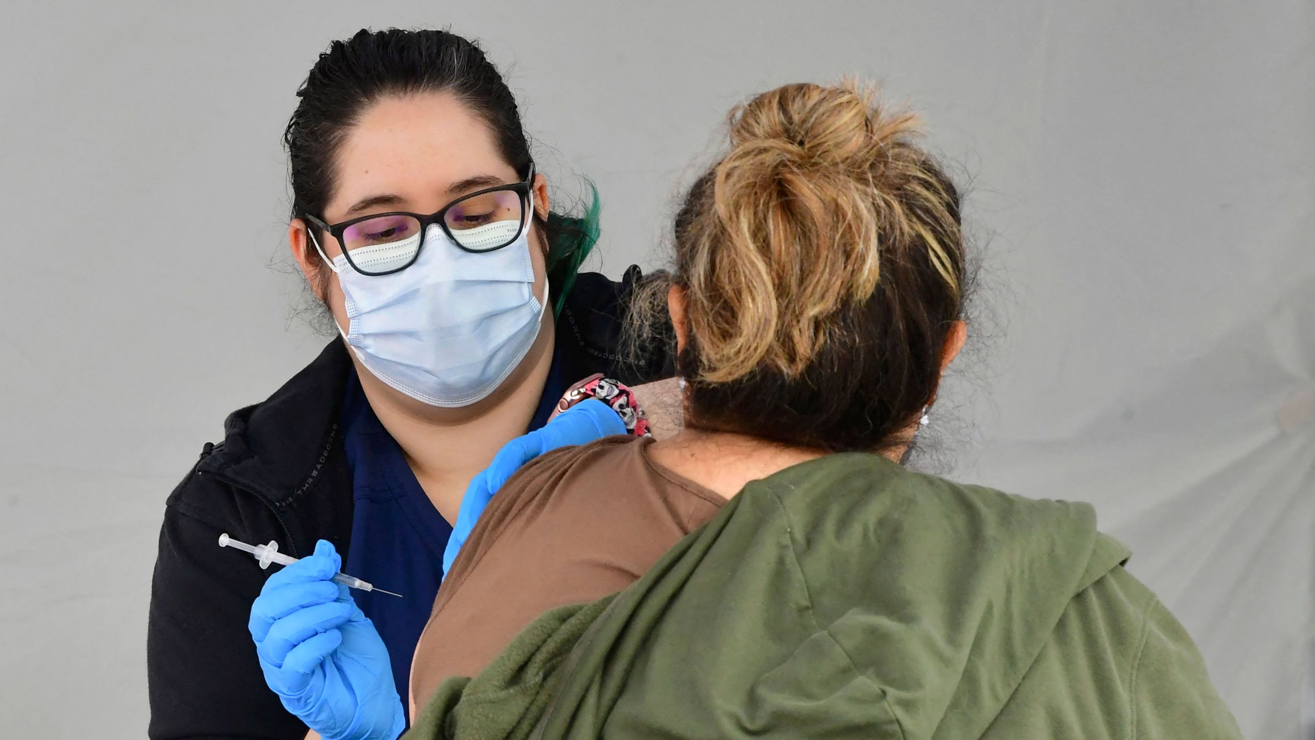 Registered Nurse Angelea Smeal administers the single-dose Johnson & Johnson Janssen Covid-19 vaccine to a woman at a vaccine rollout targetting immigrants and the undocumented organized by the St. John's Well Child and Family Center and the Los Angeles County Federation of Labour and Immigrant rights groups on March 25, 2021 in Los Angeles, California. (FREDERIC J. BROWN/AFP via Getty Images)