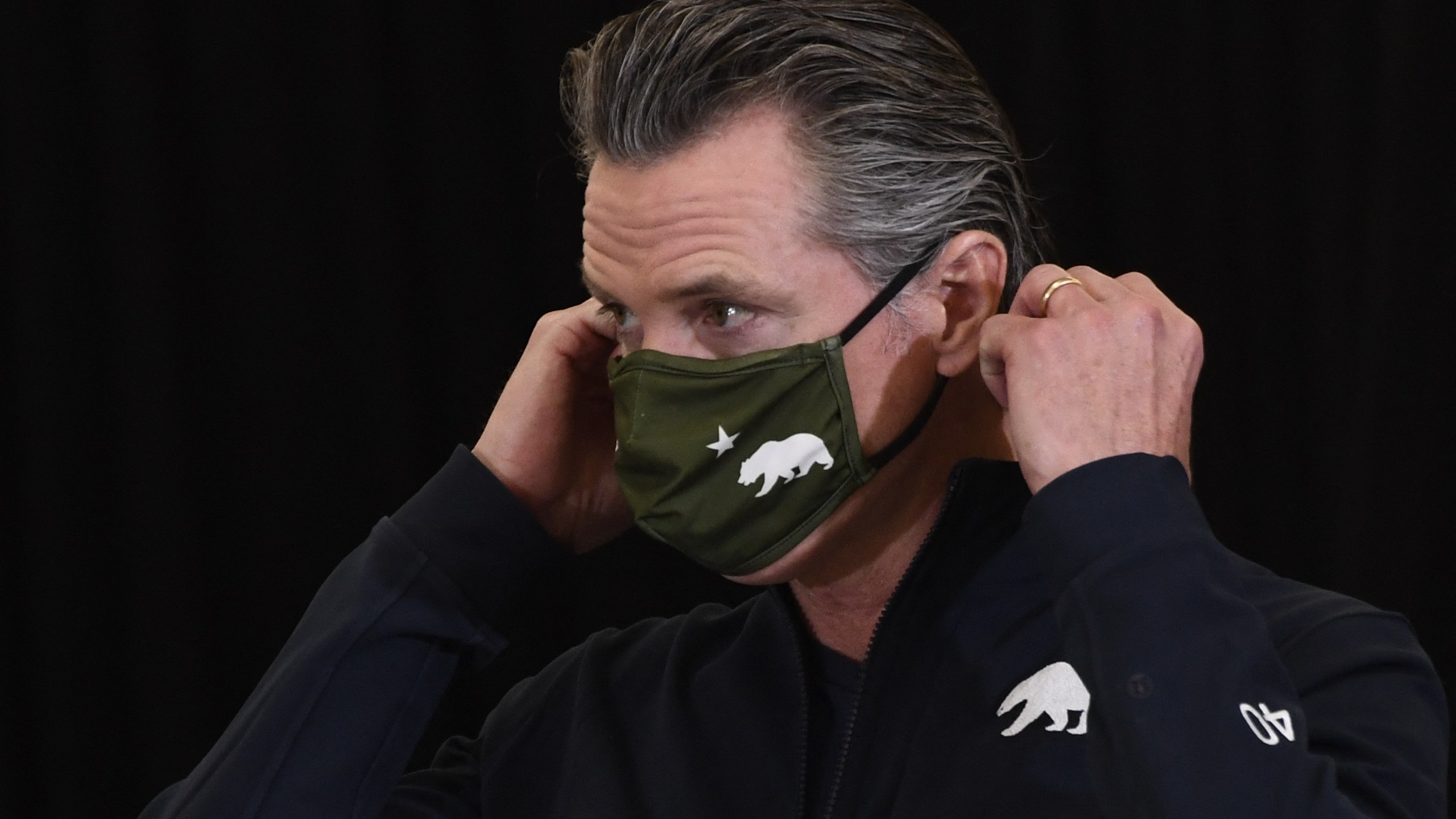 California Governor Gavin Newsom puts on his facemask after speaking to the media in Los Angeles on April 1, 2021. (PATRICK T. FALLON/AFP via Getty Images)