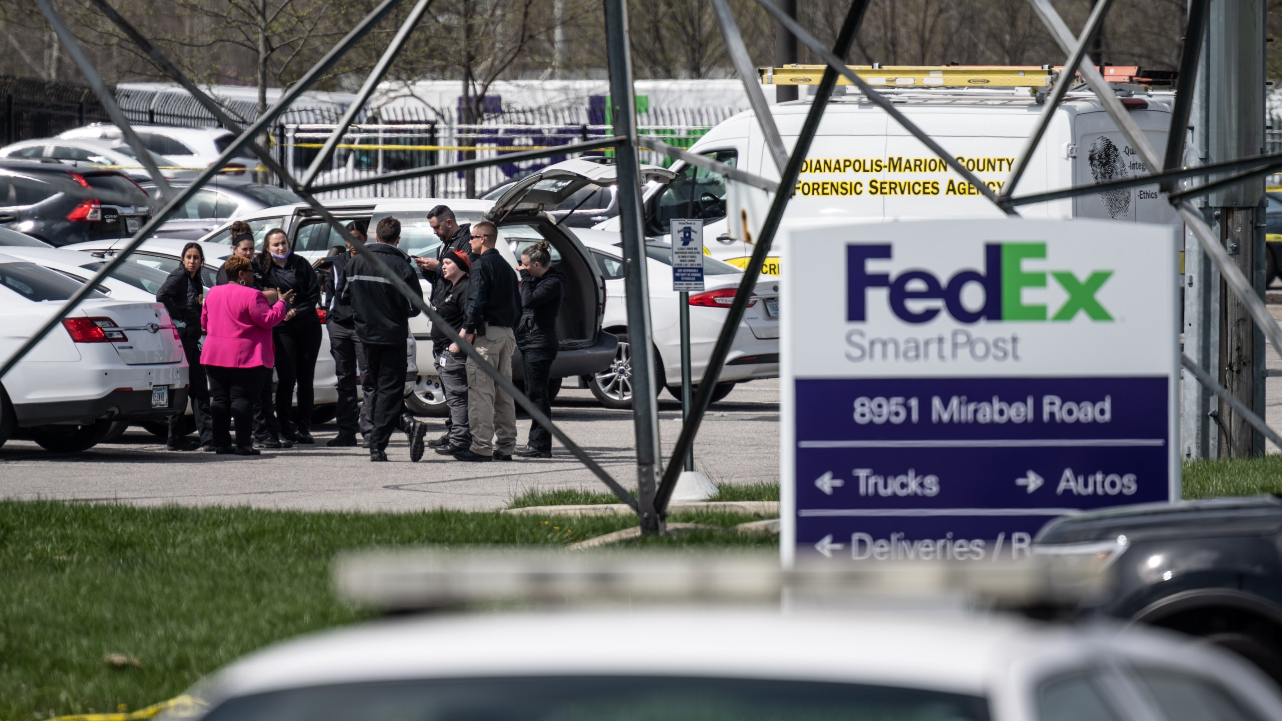 A group of crime scene investigators gather to speak in the parking lot of a FedEx SmartPost on April 16, 2021, in Indianapolis, Indiana. (Cherry/Getty Images)