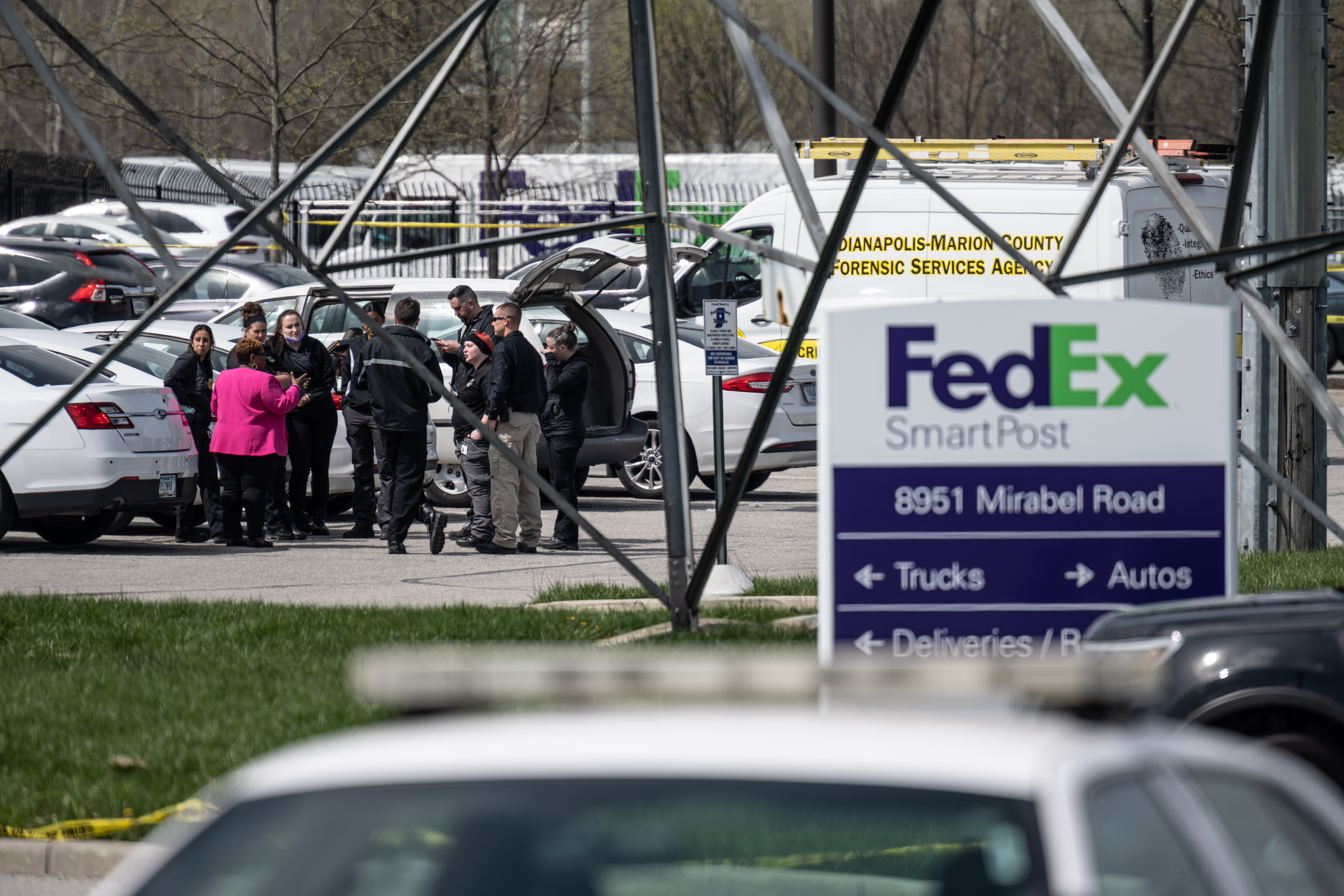 A group of crime scene investigators gather to speak in the parking lot of a FedEx SmartPost on April 16, 2021, in Indianapolis, Indiana. (Cherry/Getty Images)