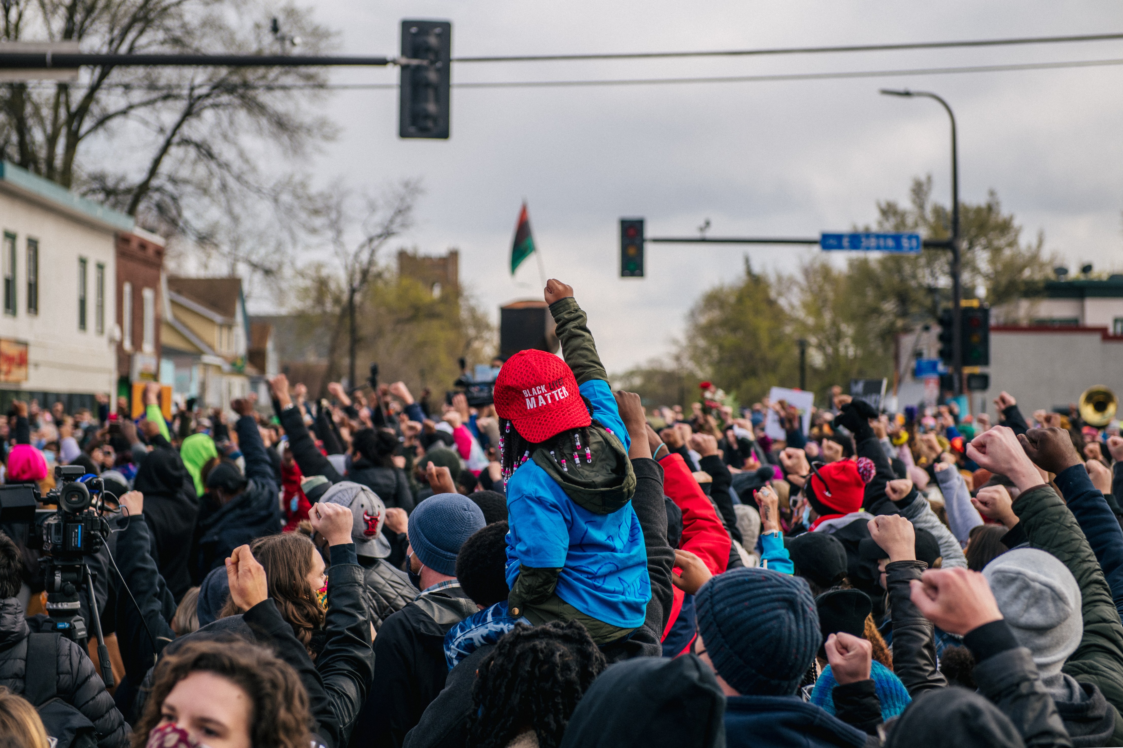 A child sits atop an adult's shoulders during a gathering at the intersection of 38th Street and Chicago Avenue in Minneapolis following the guilty verdict in Derek Chauvin’s murder trial on April 20, 2021. (Brandon Bell / Getty Images)