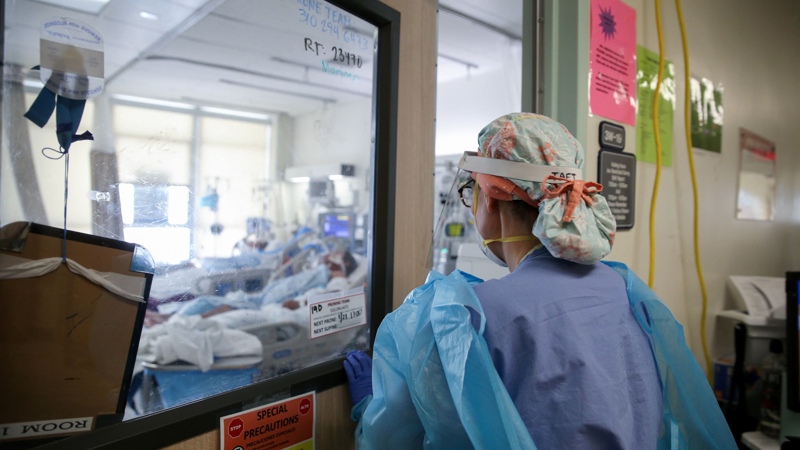 Certified registered nurse anesthetist Lisa Taft, who normally works in operating rooms, enters a room to care for COVID-19 patients in a makeshift intensive care unit at Harbor-UCLA Medical Center in Torrance on Jan. 21, 2021. (Mario Tama / Getty Images)