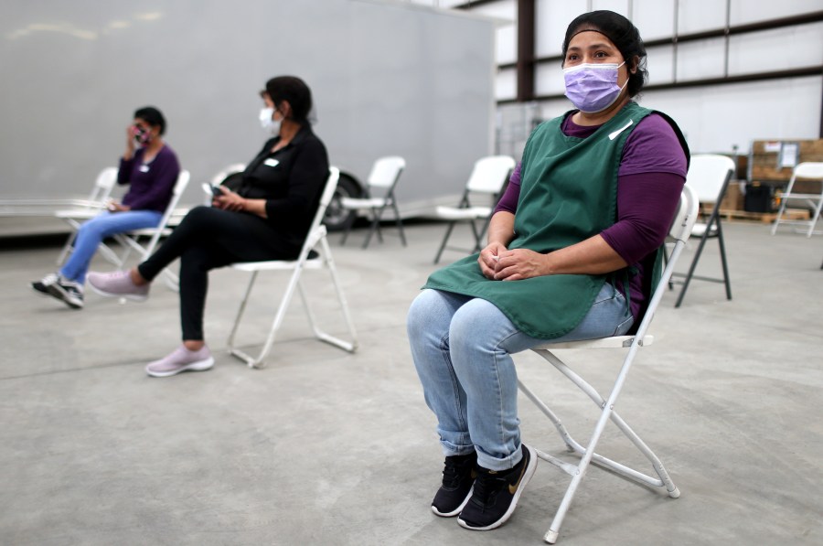 Workers sit in the observation area after receiving a one shot dose of the Johnson & Johnson COVID-19 vaccine at a clinic geared toward agriculture workers organized by TODEC on April 05, 2021 in Riverside, California. (Mario Tama/Getty Images)