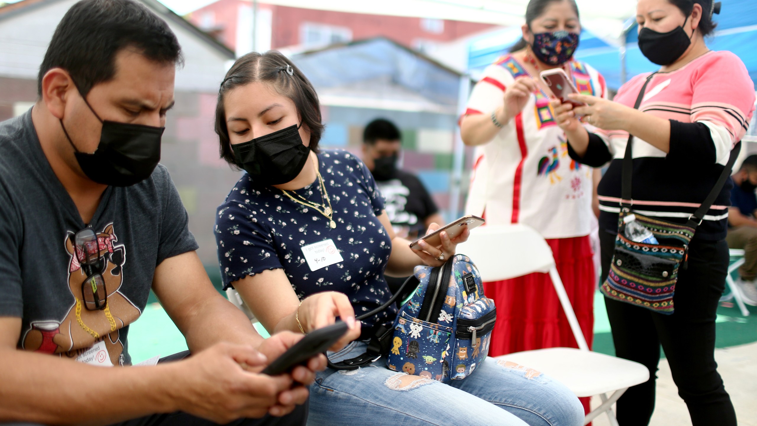 Volunteer Miriam Lopez Ambrosio (second from right) assists people with their vaccination appointments at a clinic on April 10, 2021, in Los Angeles. (Mario Tama/Getty Images)