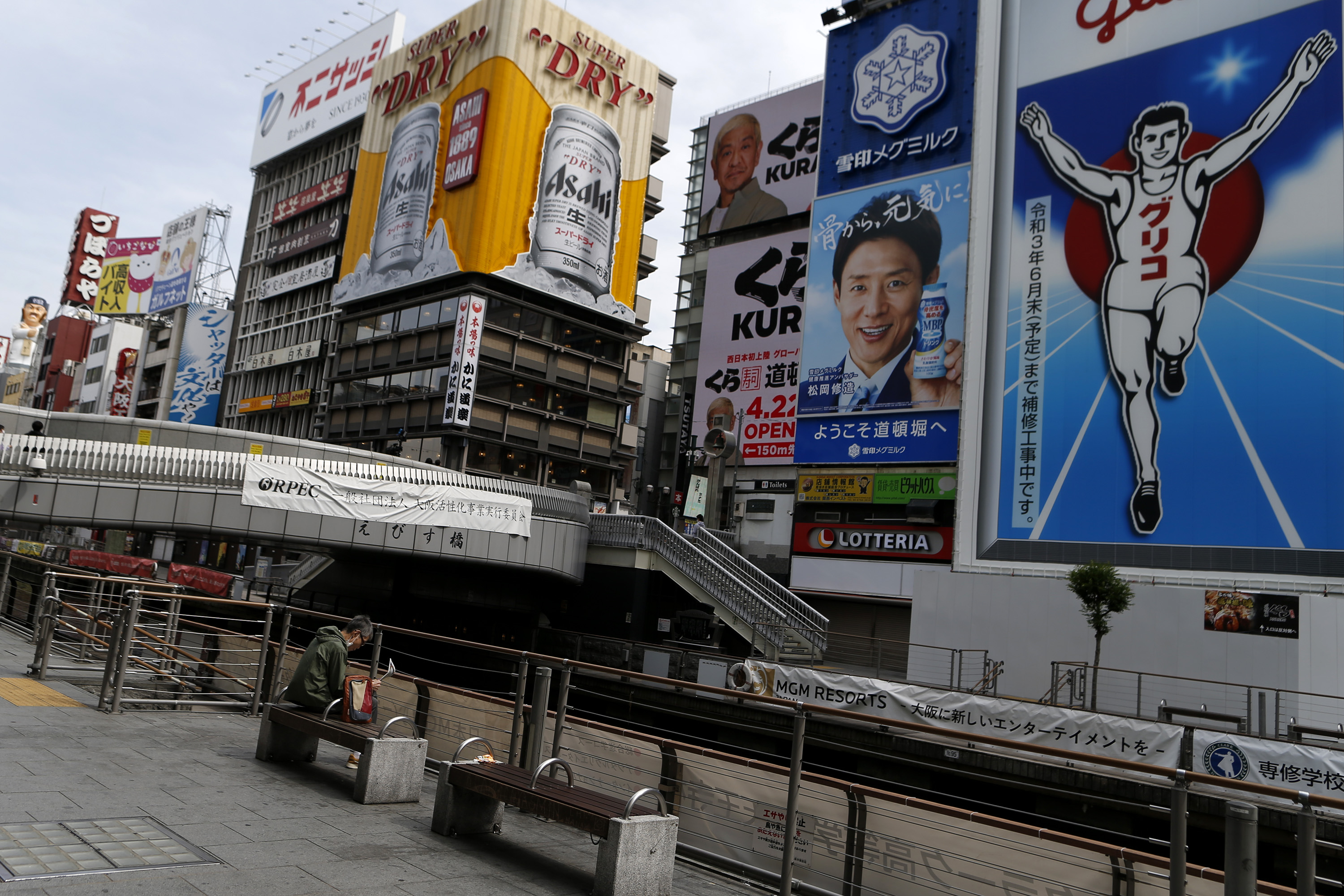 A man wearing protective face mask sits a bench at almost empty Dotonbori, one of Osaka's most popular tourist areas on April 23, 2021 in Osaka, Japan. (Buddhika Weerasinghe/Getty Images)