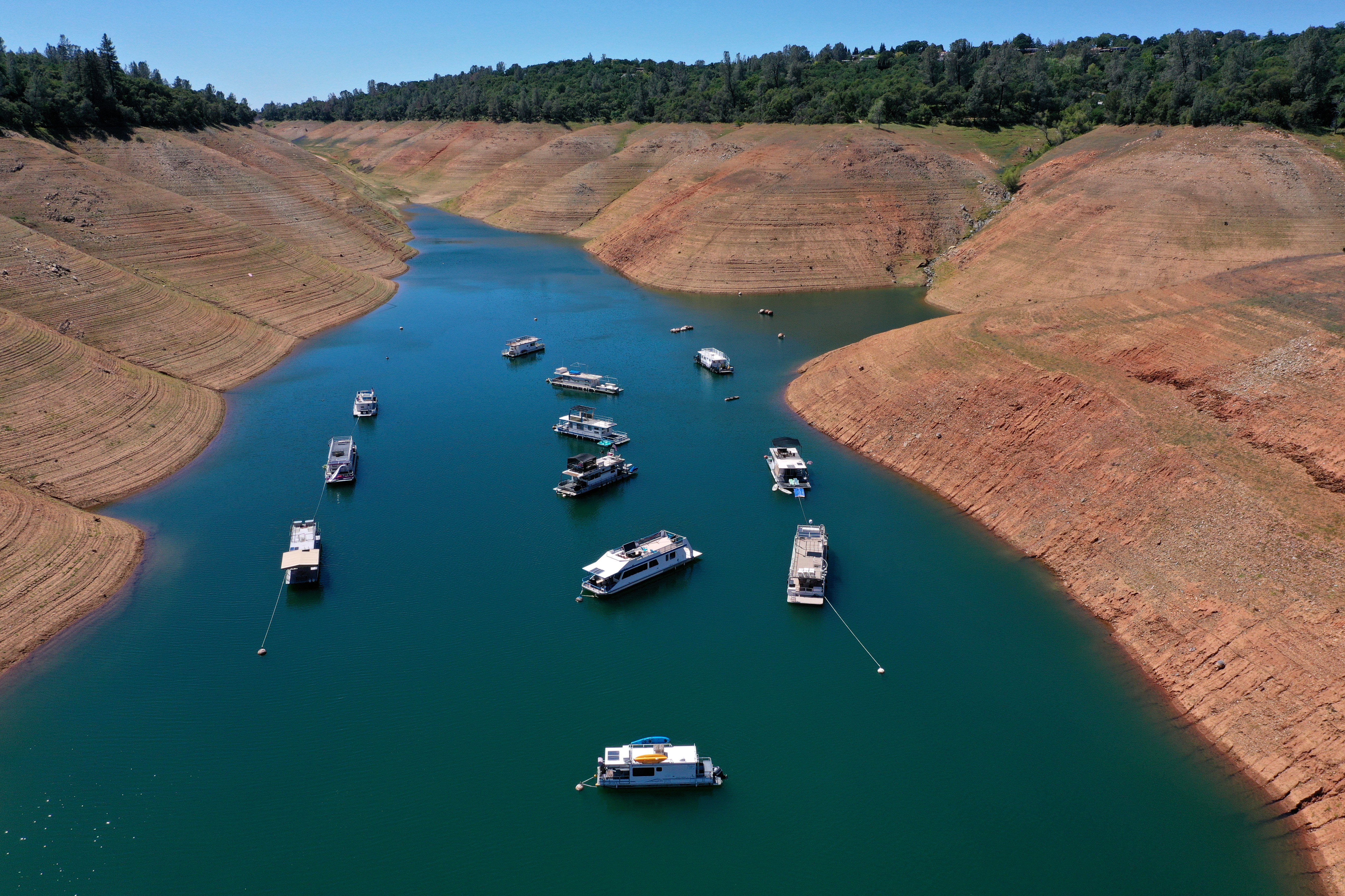 In an aerial view, houseboats are dwarfed by the steep banks of Lake Oroville on April 27, 2021 in Oroville. (Justin Sullivan/Getty Images)