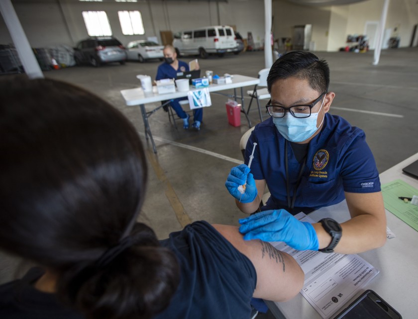 Registered nurse Justine Bertulano gives Yolanda Estrada-Saporito of Garden Grove her second dose of the Moderna COVID-19 vaccine Saturday in Gardena.(Francine Orr / Los Angeles Times)