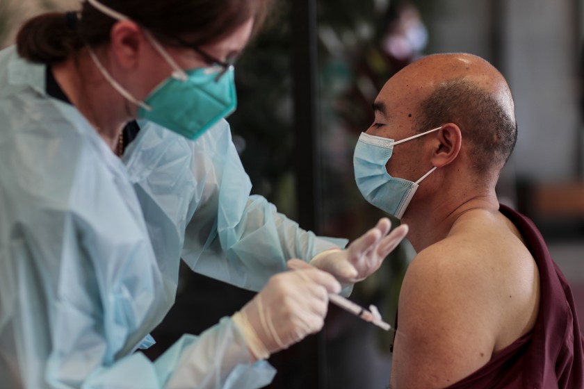 Qi Li receives a vaccination shot from Nurse Practitioner Cler Aquillas at a Covid-19 vaccination site operated by LA County and CORE in Chinatown. (Robert Gauthier/Los Angeles Times)