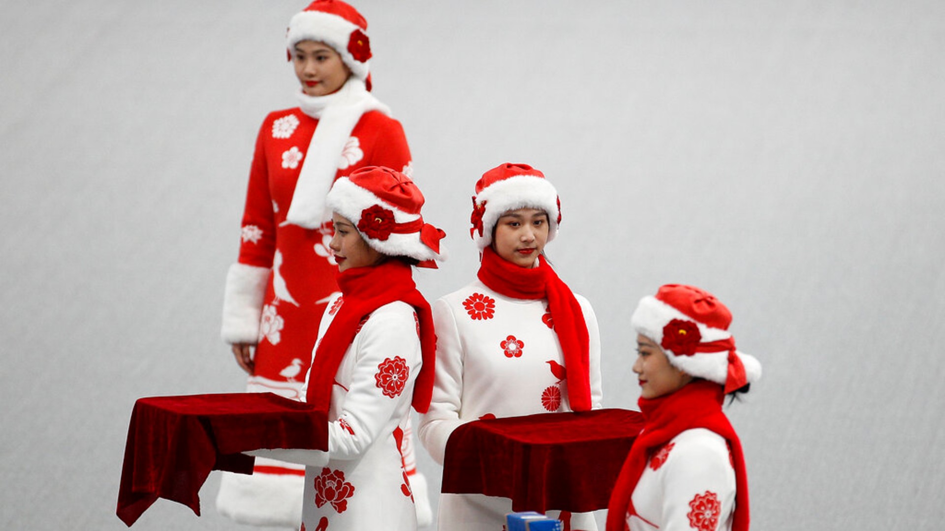 Chinese attendants dressed in winter costumes rehearse the award ceremony of the men's 500-meters race during a test event for the 2022 Beijing Winter Olympics at the National Speed Skating Oval in Beijing, Wednesday, April 7, 2021. (AP Photo/Andy Wong)