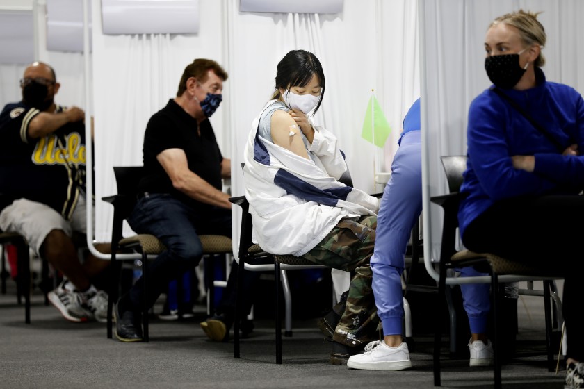 Huong Vu, 20, of Santa Ana receives a dose of the Moderna COVID-19 vaccine at Edwards Lifesciences in Santa Ana on April 22.(Christina House / Los Angeles Times )