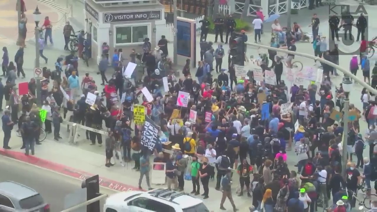 Counterprotesters and people participating in the so-called White Lives Matter rally gather in Huntington Beach on April 11, 2021. (KTLA)