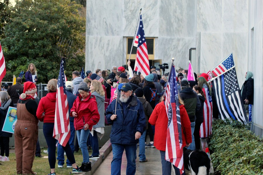 In this Dec. 21, 2020, file photo, pro-Trump and anti-mask demonstrators hold a rally outside the Oregon State Capitol as legislators meet for an emergency session in Salem, Ore. Prosecutors leveled two criminal charges Friday, April 30, 2021, against a Republican member of the Oregon House of Representatives who let far-right rioters into the state Capitol that day. Rep. Mike Nearman was charged with official misconduct in the first degree and criminal trespass in the second degree. (AP Photo/Andrew Selsky, File)