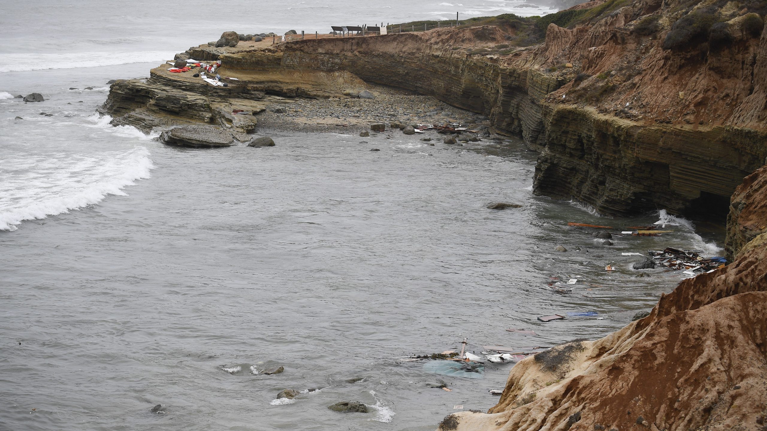 Wreckage and debris from a capsized boat washes ashore at Cabrillo National Monument near where a boat capsized just off the San Diego coast on May 2, 2021. (Denis Poroy / Associated Press)