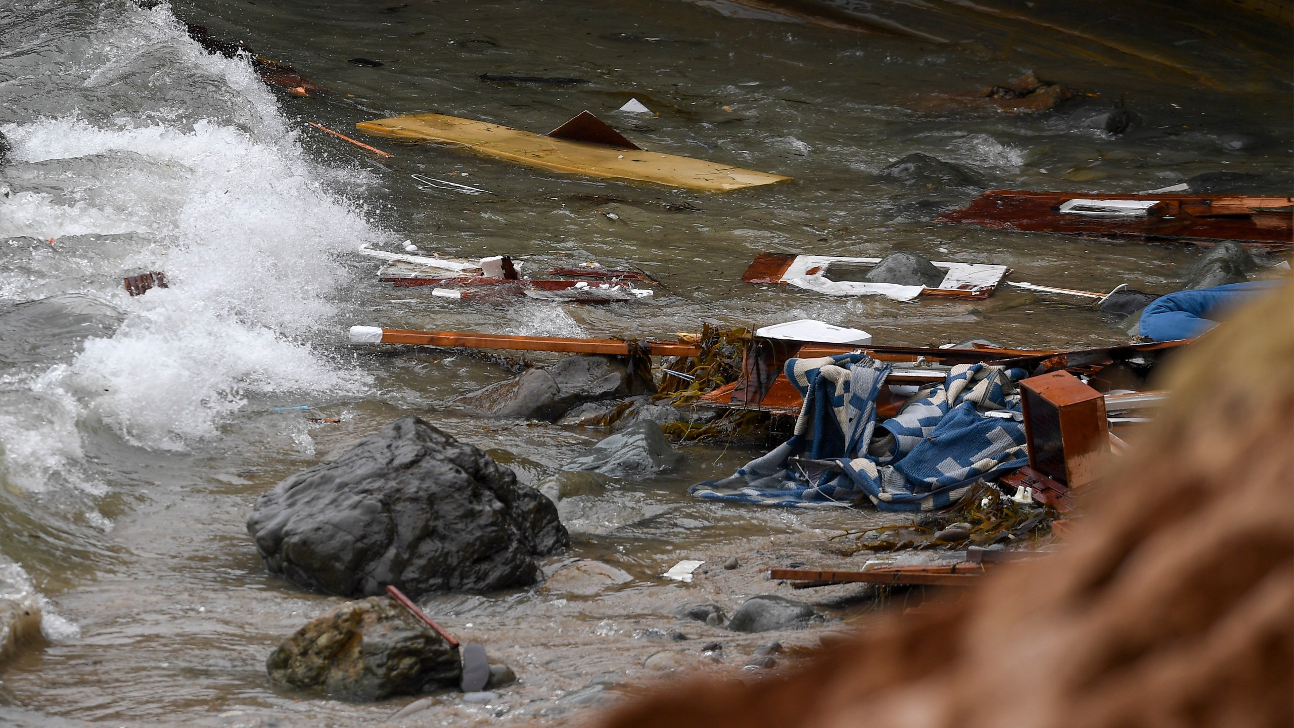 Wreckage and debris from a capsized boat washes ashore at Cabrillo National Monument near where a boat capsized just off the San Diego coast on May 2, 2021. (Denis Poroy / Associated Press)