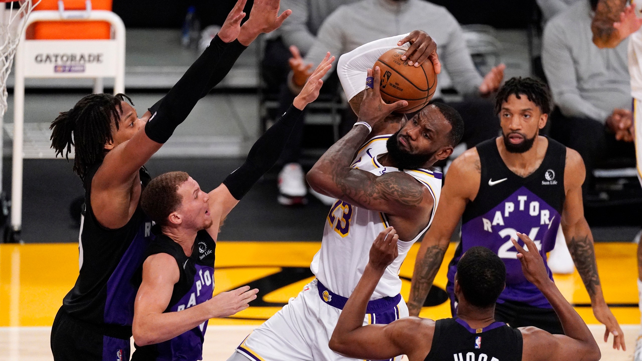 Los Angeles Lakers forward LeBron James, center, tries to shoot as Toronto Raptors forward Freddie Gillespie, left, guard Malachi Flynn, second from left, guard Rodney Hood, second from right, and center Khem Birch defend during the first half of an NBA basketball game Sunday, May 2, 2021, in Los Angeles. (AP Photo/Mark J. Terrill)