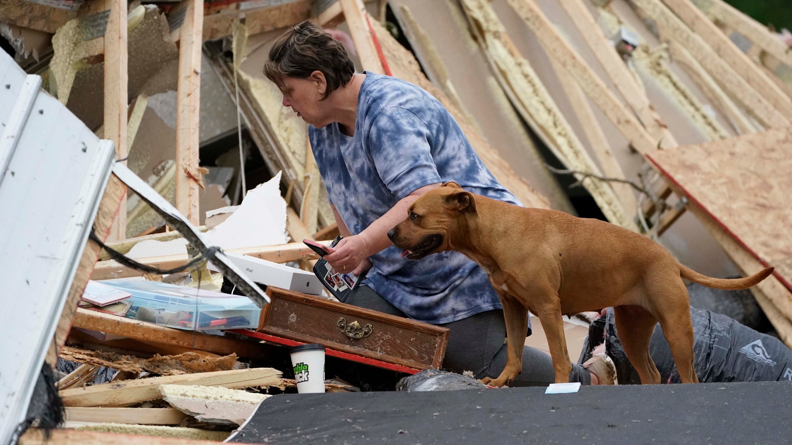 Vickie Savell looks through her belongings amid the remains of her new mobile home early Monday, May 3, 2021, in Yazoo County, Miss. (AP Photo/Rogelio V. Solis)