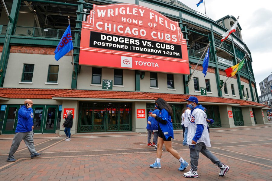 Fans walk outside Wrigley Field as a baseball game between the Chicago Cubs and the Los Angels Dodgers was postponed due to the forecast of inclement weather, Monday, May 3, 2021, in Chicago. (AP Photo/Kamil Krzaczynski)