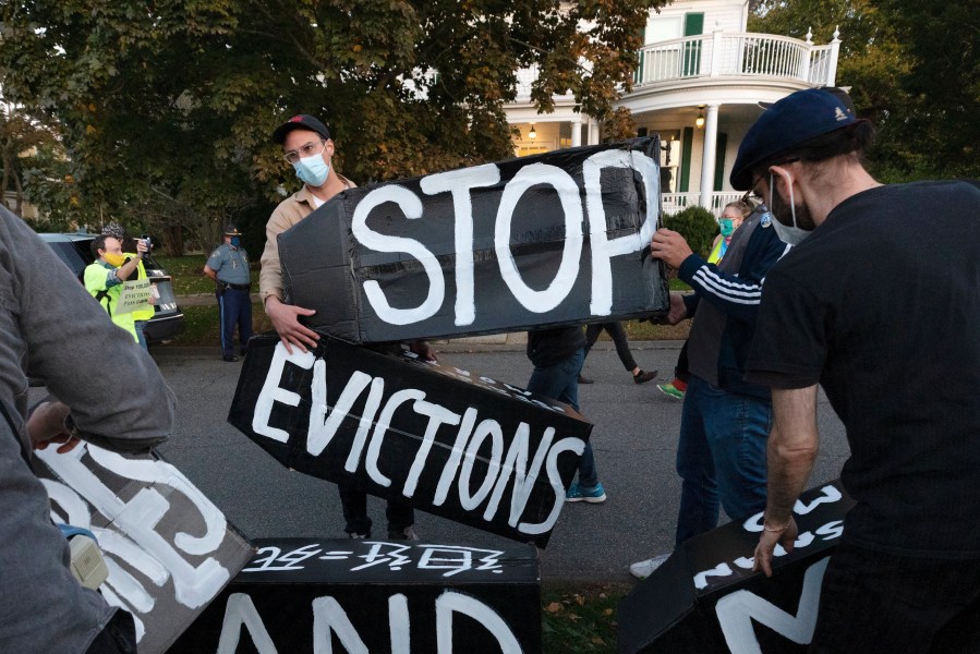 In this Oct. 14, 2020, file photo, housing activists erect a sign in front of Massachusetts Gov. Charlie Baker's house in Swampscott, Mass. (AP Photo/Michael Dwyer, File)