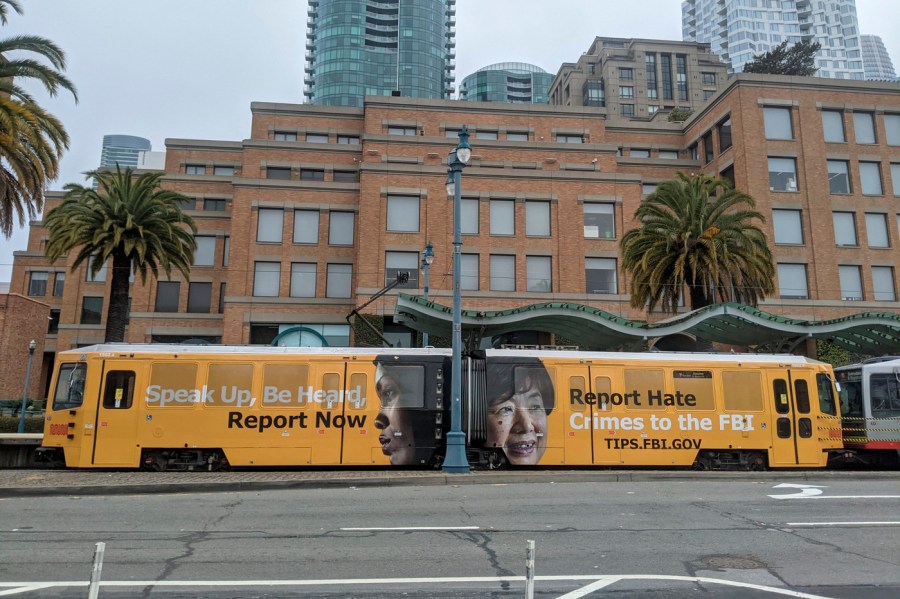 In this image provided by the FBI, an ad on a San Francisco city train reads "Speak Up, Be Heard, Report Now. Report Hate Crimes to the FBI." as part of a publicity campaign by the San Francisco FBI office to encourage victims of hate crimes to come forward and report hate incidents, federal officials announced Thursday, May 6, 2021. It also launched a social media campaign that includes the photo of an elderly Asian woman and a message that reads, "Did you know many hate crimes are not reported? The FBI wants to help but we need to hear from you." (FBI via AP)