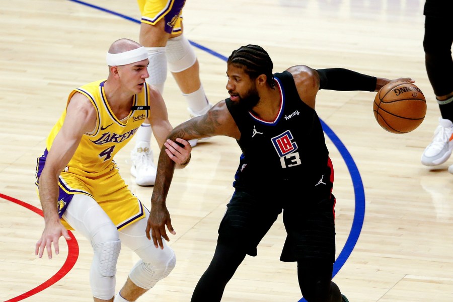 Los Angeles Clippers' Paul George is defended by Los Angeles Lakers' Alex Caruso during the first half of an NBA basketball game at the Staples Center on May 6, 2021. (Ringo H.W. Chiu / Associated Press)