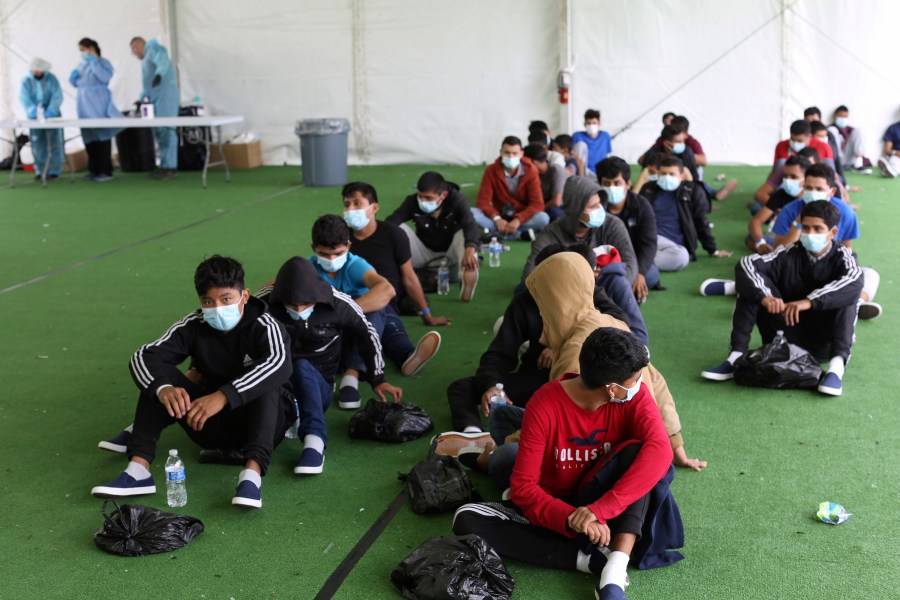 In this March 30, 2021 file photo, young migrants wait to be tested for COVID-19 at the Donna Department of Homeland Security holding facility, the main detention center for unaccompanied children in the Rio Grande Valley, in Donna, Texas. (AP Photo/Dario Lopez-Mills, Pool, File)