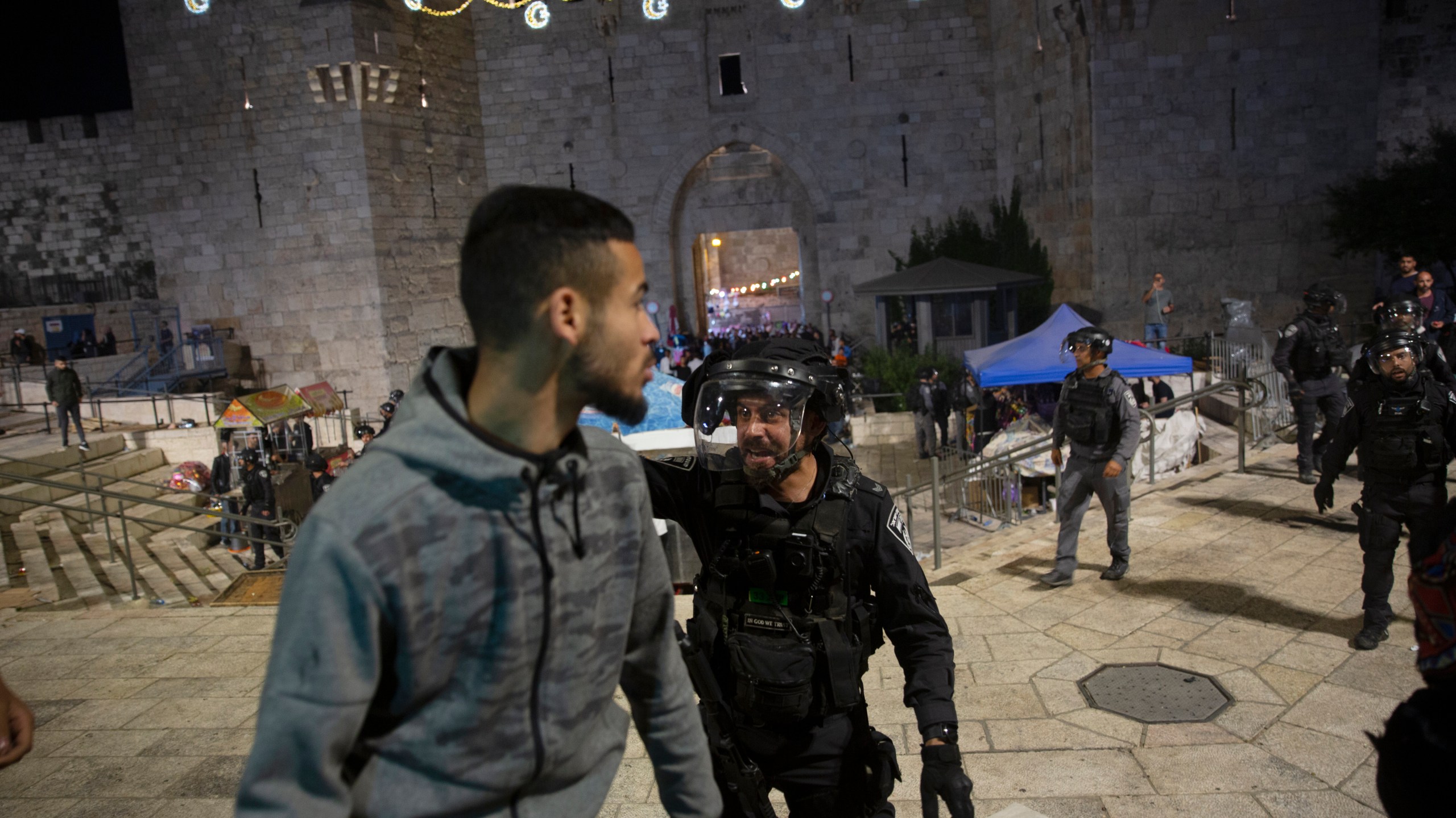 An Israeli policeman shouts at a Palestinian man to leave the Damascus Gate to the Old City of Jerusalem after clashes at the Al-Aqsa Mosque compound on May 7, 2021. (Maya Alleruzzo / Associated Press)