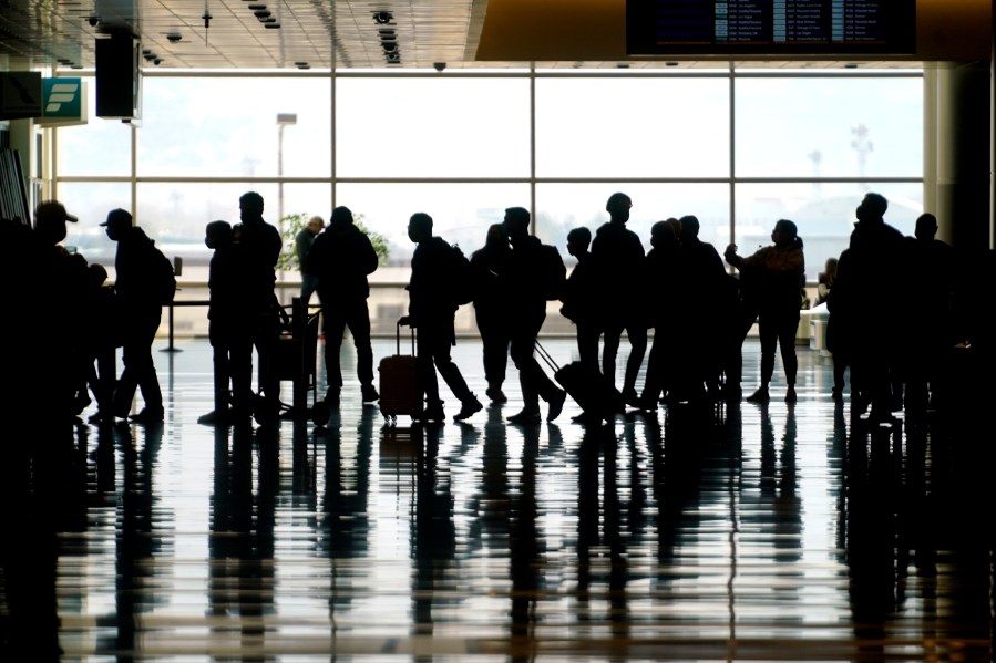 Travelers walk through the Salt Lake City International Airport in Salt Lake City on March 17, 2021. (Rick Bowmer / Associated Press)