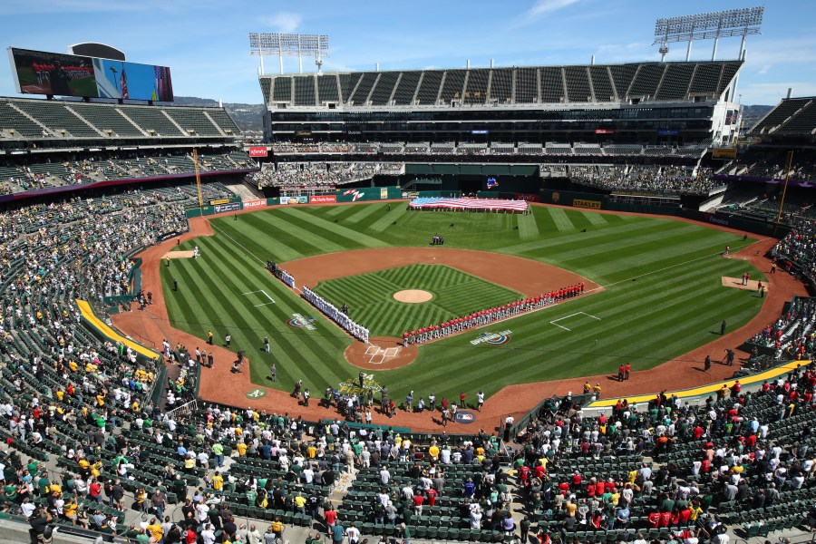 The Los Angeles Angels and Oakland Athletics stand for the national anthem at the Oakland Coliseum prior to an opening day baseball game in Oakland, Calif., in this Thursday, March 29, 2018, file photo.Major League Baseball instructed the Athletics to explore relocation options as the team tries to secure a new ballpark it hopes will keep the club in Oakland in the long term. MLB released a statement Tuesday, May 11, 2021, expressing its longtime concern that the current Coliseum site is “not a viable option for the future vision of baseball.” (AP Photo/Ben Margot, File)