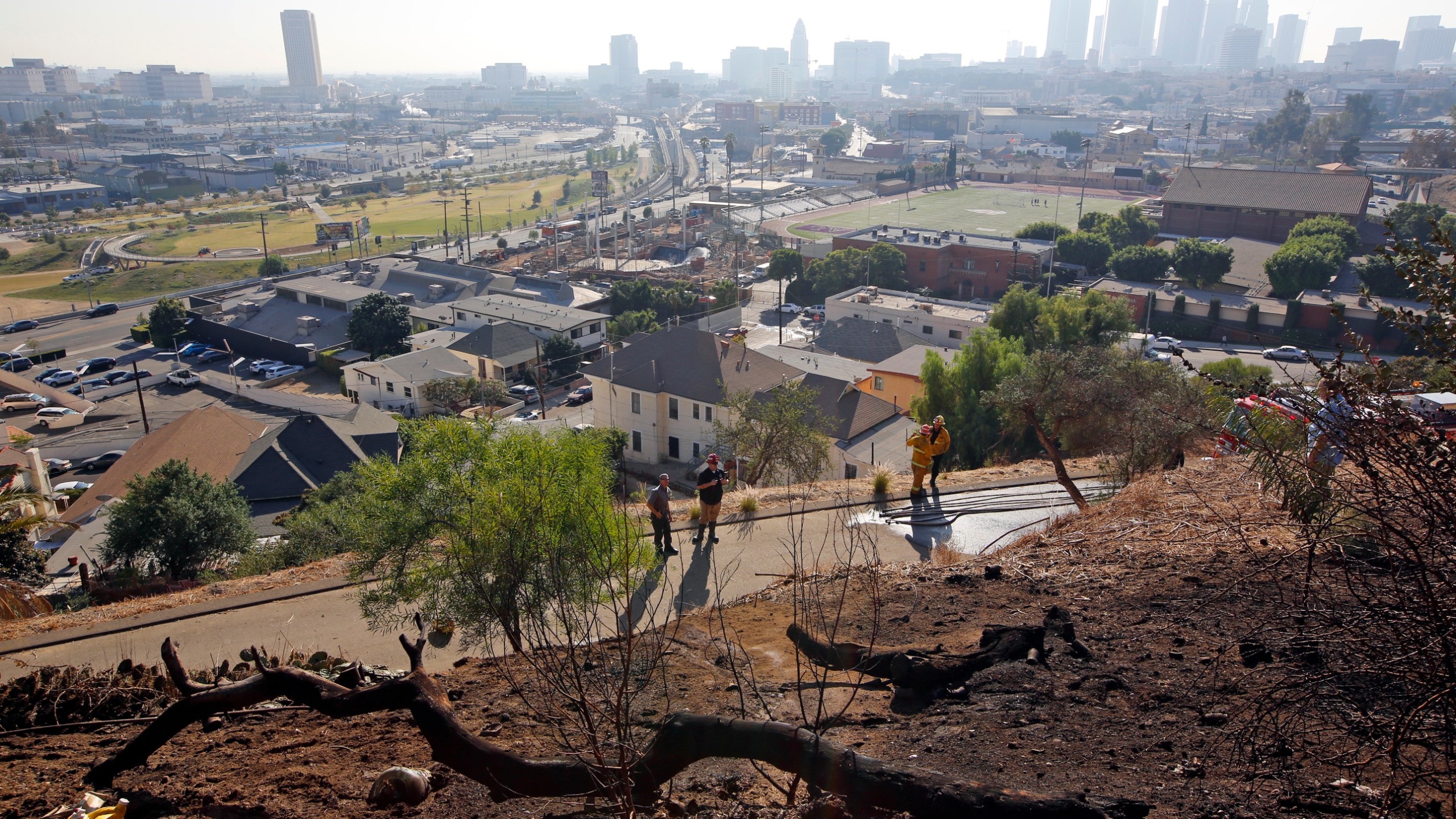 In this Dec. 14, 2017, file photo, Los Angeles Fire Department Arson Counter-Terrorism investigators check a burned-out homeless camp after a brush fire erupted in the hills in Elysian Park near downtown Los Angeles. Authorities say fires linked to homeless tents and camps are raising concern in Los Angeles, where they have claimed seven lives and caused tens of millions of dollars in damage to nearby businesses. The Los Angeles Times says the Fire Department handled 24 such fires a day in the first quarter of this year. (AP Photo/Damian Dovarganes, File)