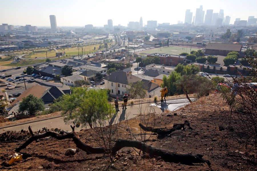 In this Dec. 14, 2017, file photo, Los Angeles Fire Department Arson Counter-Terrorism investigators check a burned-out homeless camp after a brush fire erupted in the hills in Elysian Park near downtown Los Angeles. Authorities say fires linked to homeless tents and camps are raising concern in Los Angeles, where they have claimed seven lives and caused tens of millions of dollars in damage to nearby businesses. The Los Angeles Times says the Fire Department handled 24 such fires a day in the first quarter of this year. (AP Photo/Damian Dovarganes, File)