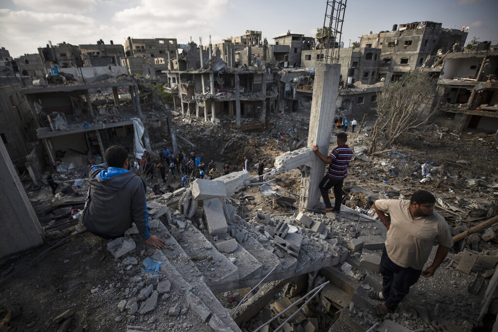 Palestinians inspect their destroyed houses following overnight Israeli airstrikes in town of Beit Hanoun, northern Gaza Strip, Friday, May 14, 2021. (AP Photo/Khalil Hamra)