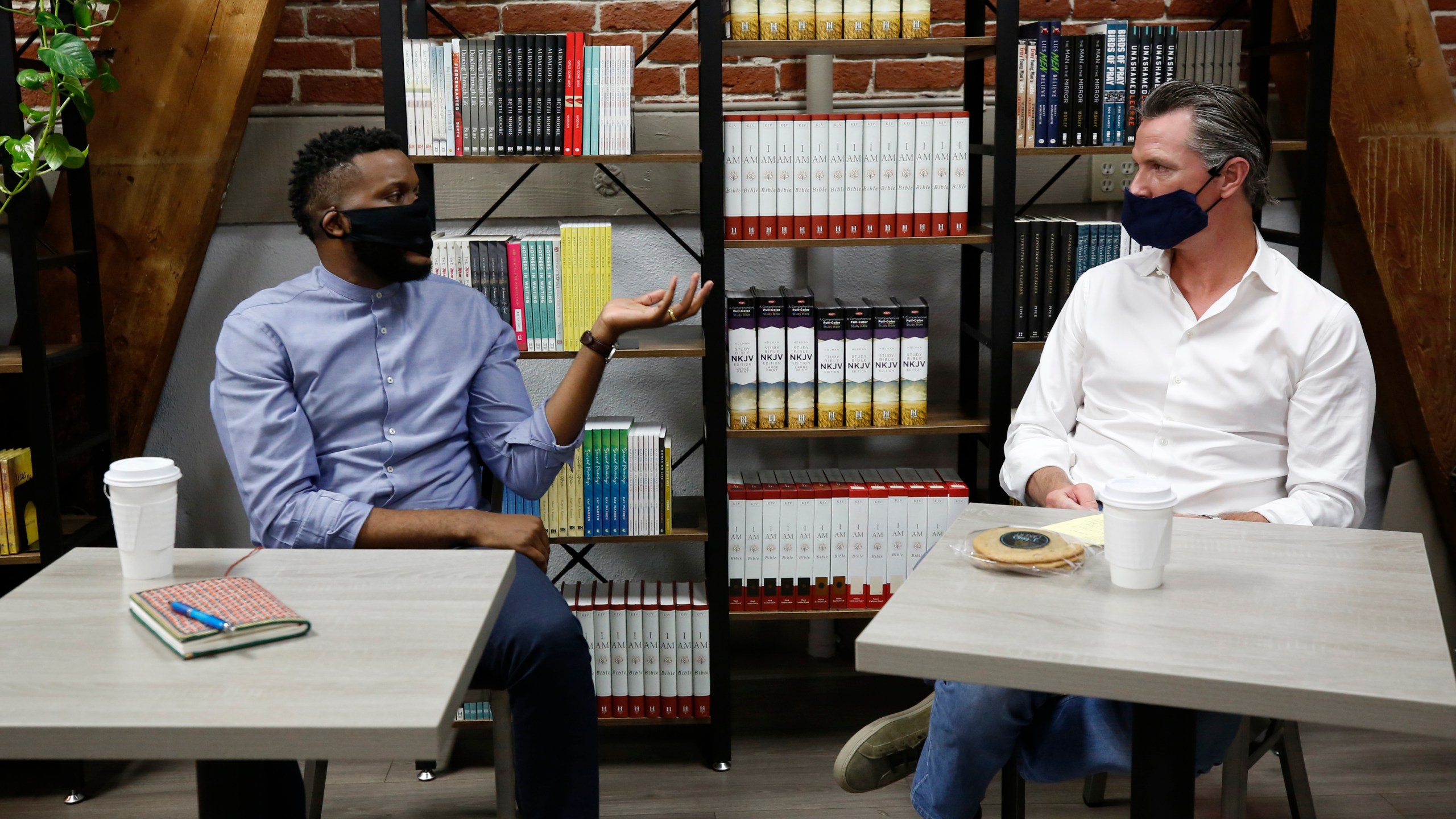 Then-Stockton Mayor Michael Tubbs, left, discusses his city with California Gov. Gavin Newsom, right, during a visit to Legendary Coffee and Books in Stockton on June 4, 2020. (Rich Pedroncelli / Associated Press)