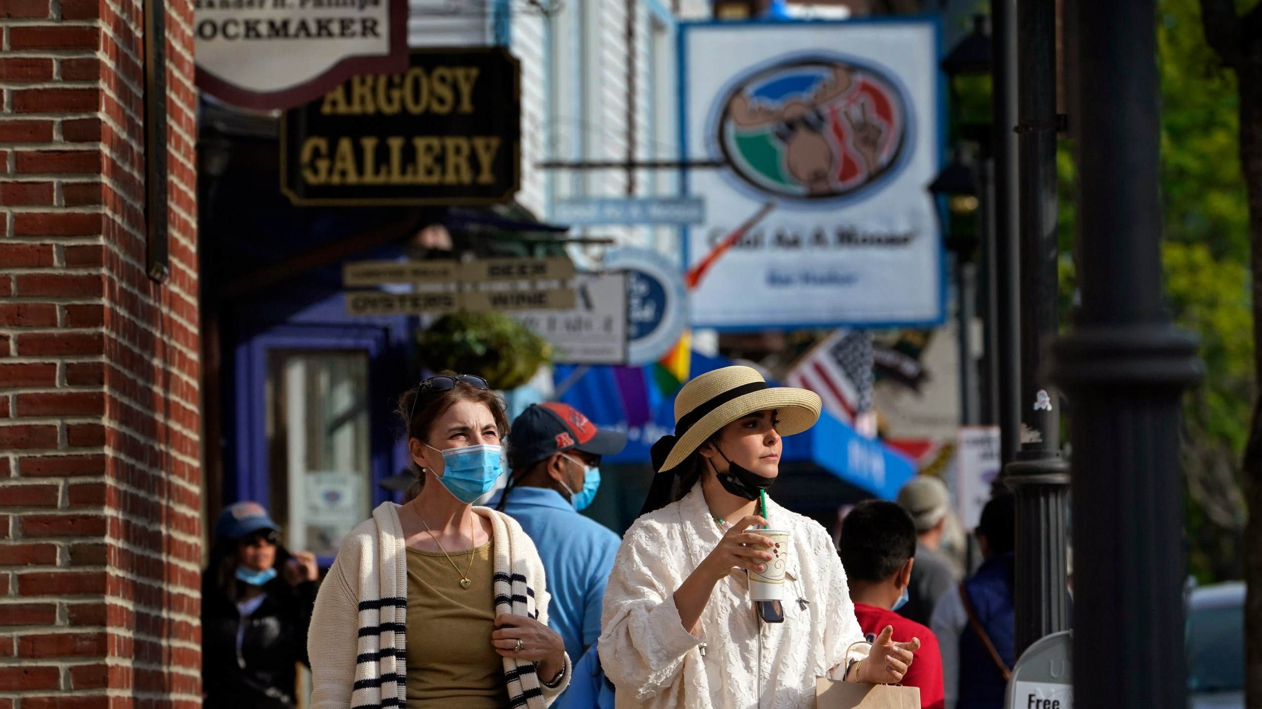 Visitors walk on a busy sidewalk, Saturday, May 15, 2021, in Bar Harbor, Maine. Gov. Janet Mills is is eliminating most outdoor distancing requirements imposed during the COVID-19 pandemic as the tourism season begins to kick into gear. (AP Photo/Robert F. Bukaty)