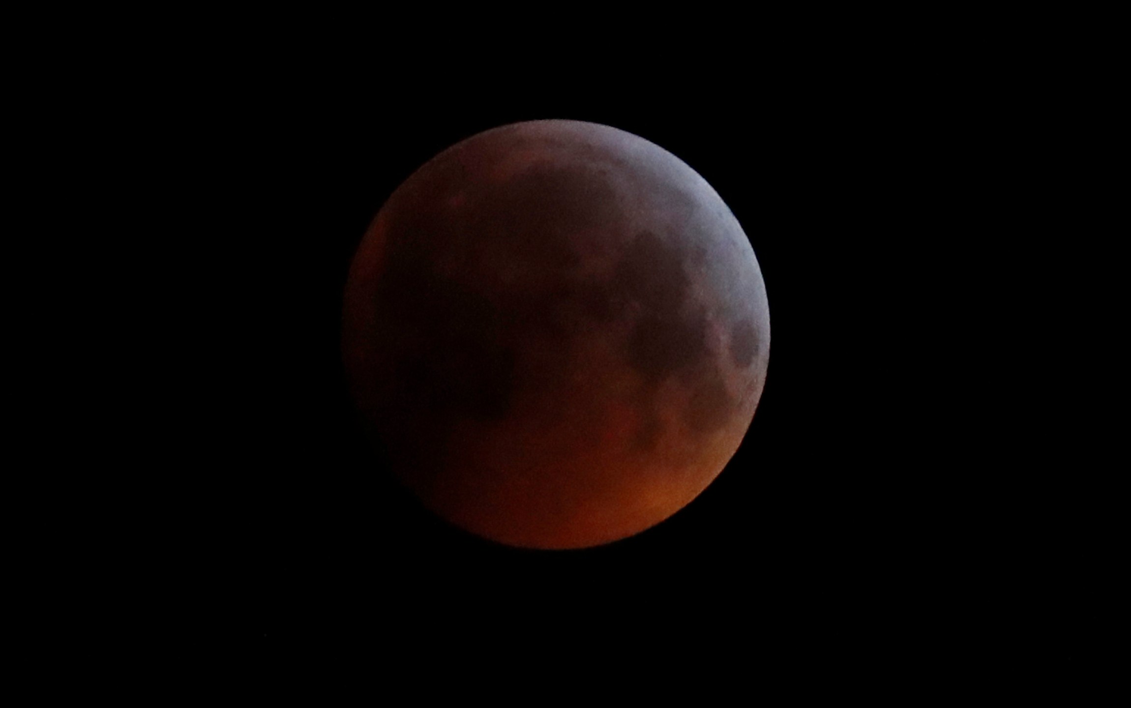 In this Monday, Jan. 21, 2019 file photo, the Earth's shadow falls across the full moon seen above Brighton, southeast England. The first total lunar eclipse in more than two years coincides with a supermoon this week for a cosmic show. This super “blood” moon will be visible Wednesday, May 26, 2021 across the Pacific _ offering the best viewing _ as well as the western half of North America, bottom of South America and eastern Asia. (AP Photo/Alastair Grant, File)