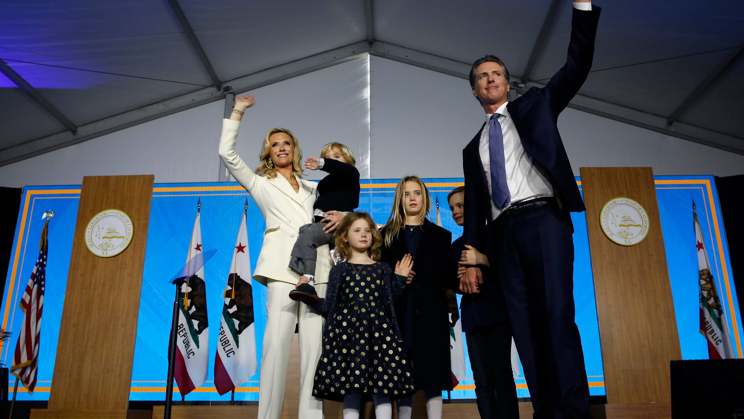 In this Jan. 7, 2019, file photo California Governor Gavin Newsom his wife, Jennifer Siebel Newsom, and their children wave after taking the oath office during his inauguration as 40th Governor of California, in Sacramento, Calif. (AP Photo/Rich Pedroncelli, File)