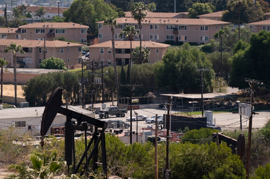 Apartment buildings are seen behind pump jacks operating at the Inglewood Oil Field in Los Angeles, Tuesday, May 18, 2021. (AP Photo/Jae C. Hong)